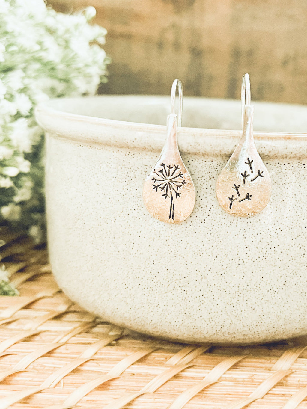Pair of earrings with tree design on a textured surface