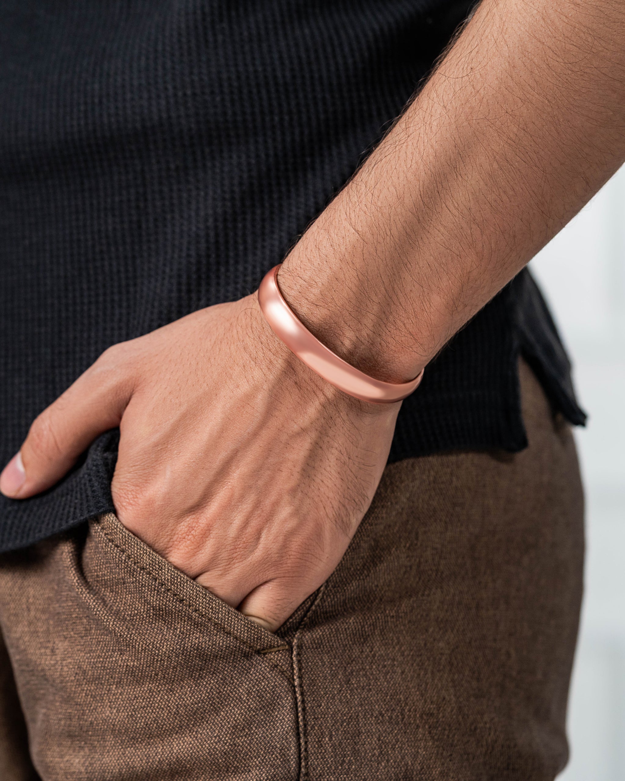 Person wearing a rose gold bracelet on a blurred background