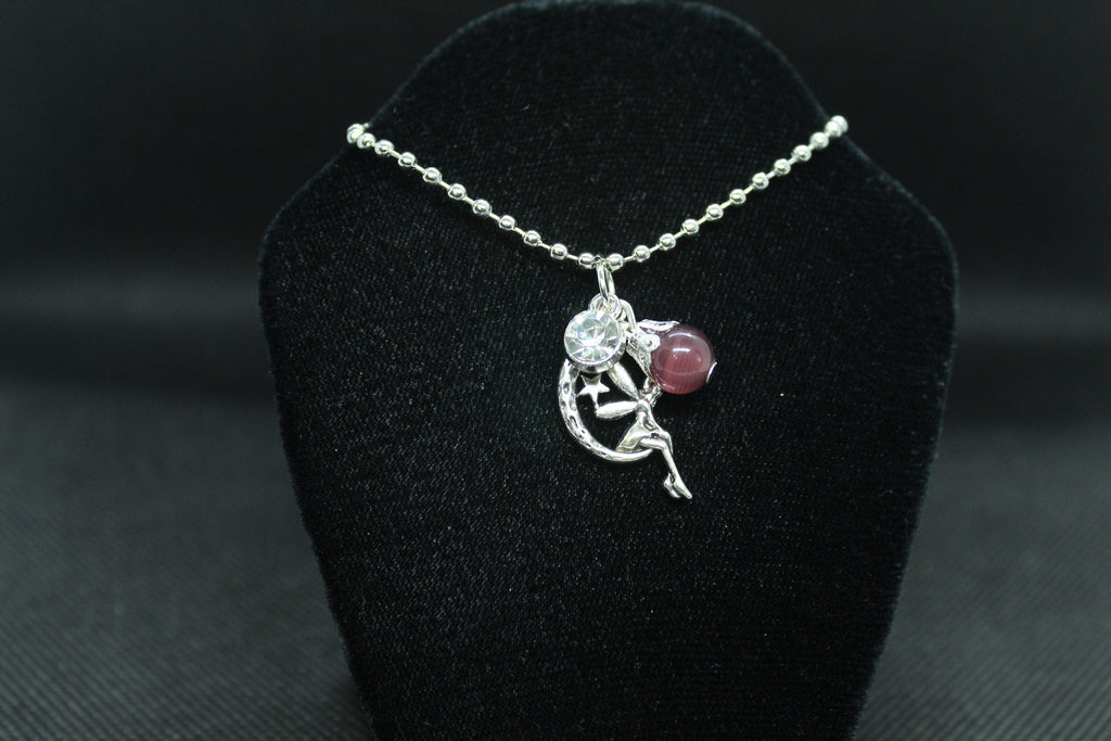 silver necklace with pendant on a black velvet stand