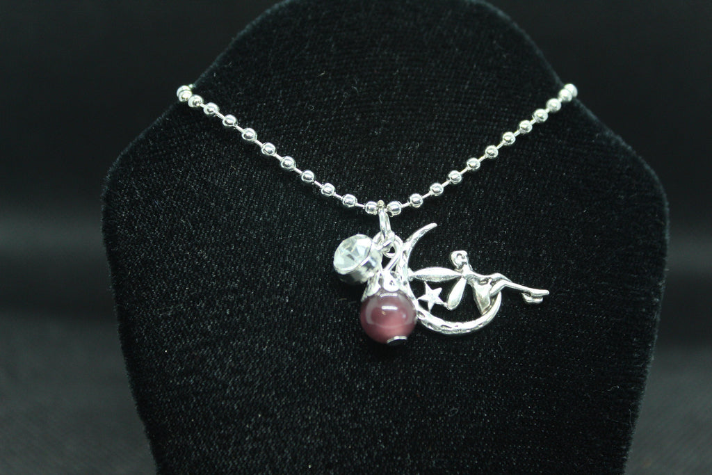 silver necklace with pendant on a black velvet stand