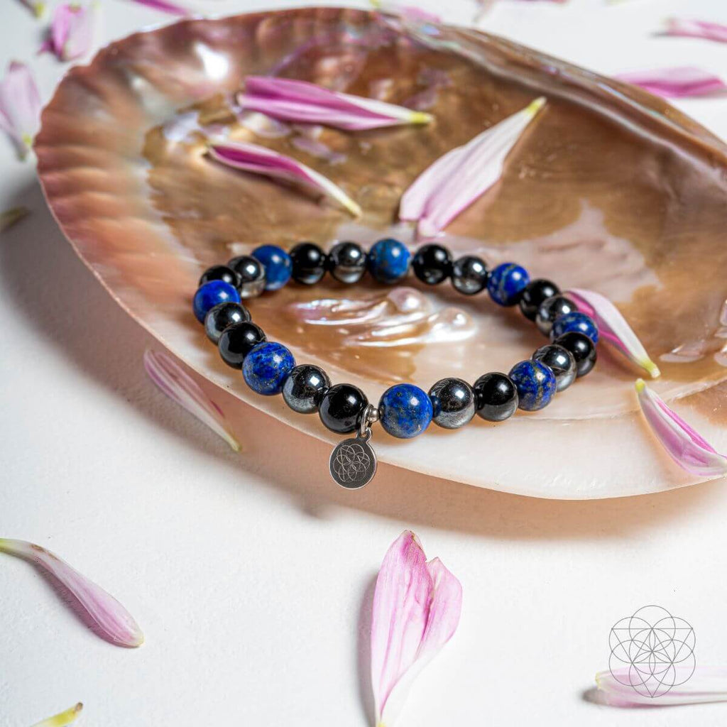 Bracelet with blue and black beads on a shell with pink flowers