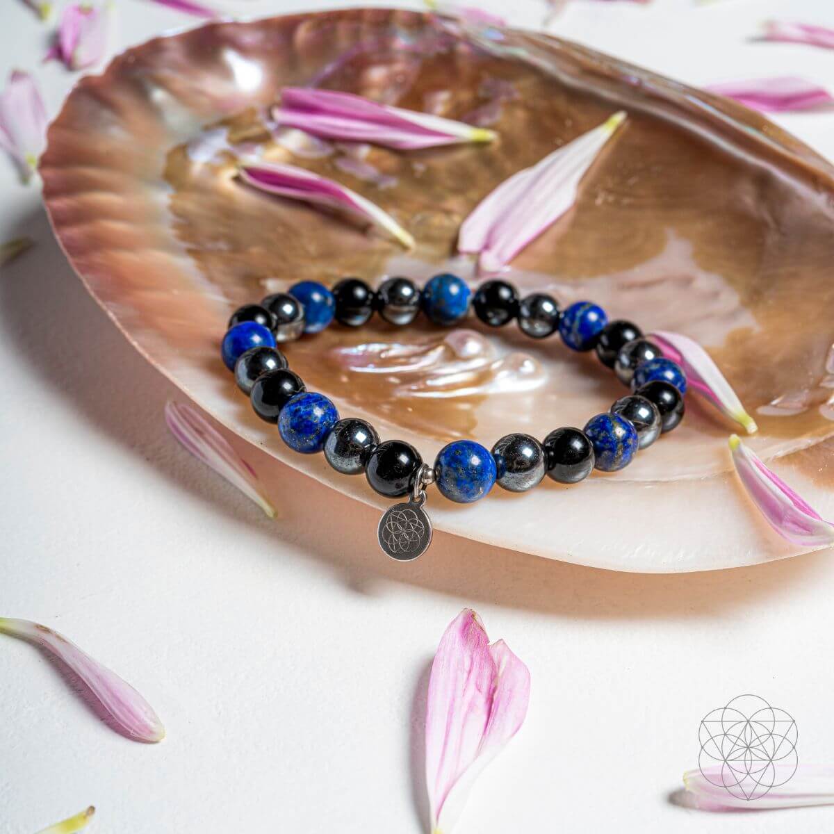 Bracelet with blue and black beads on a shell with pink flowers