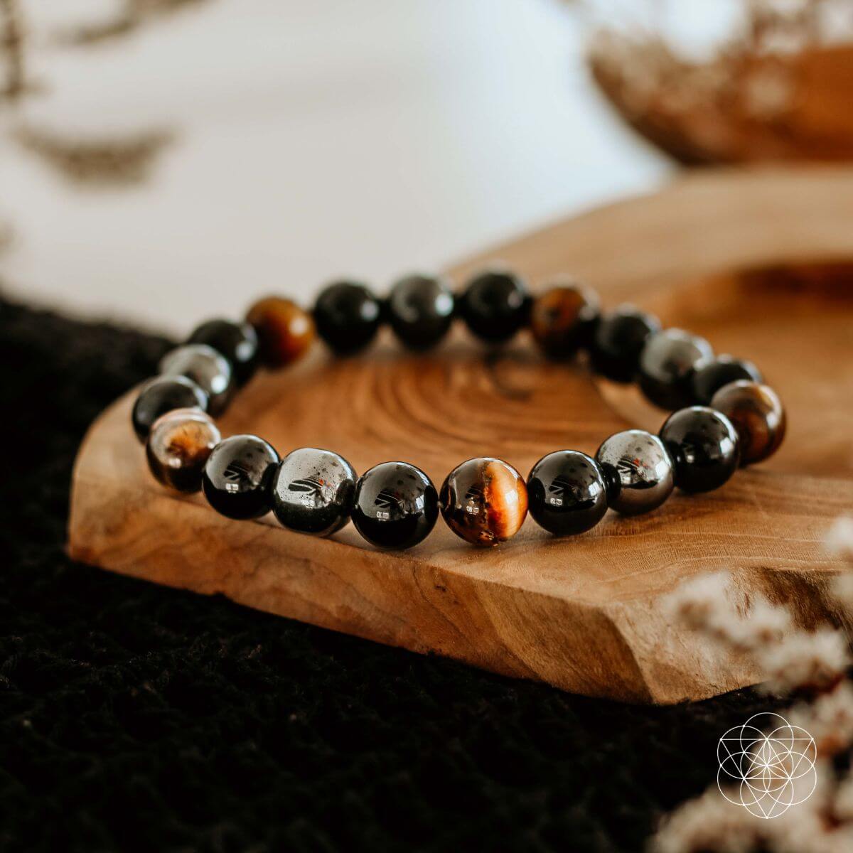 Black beaded bracelet with brown accents on a wooden surface